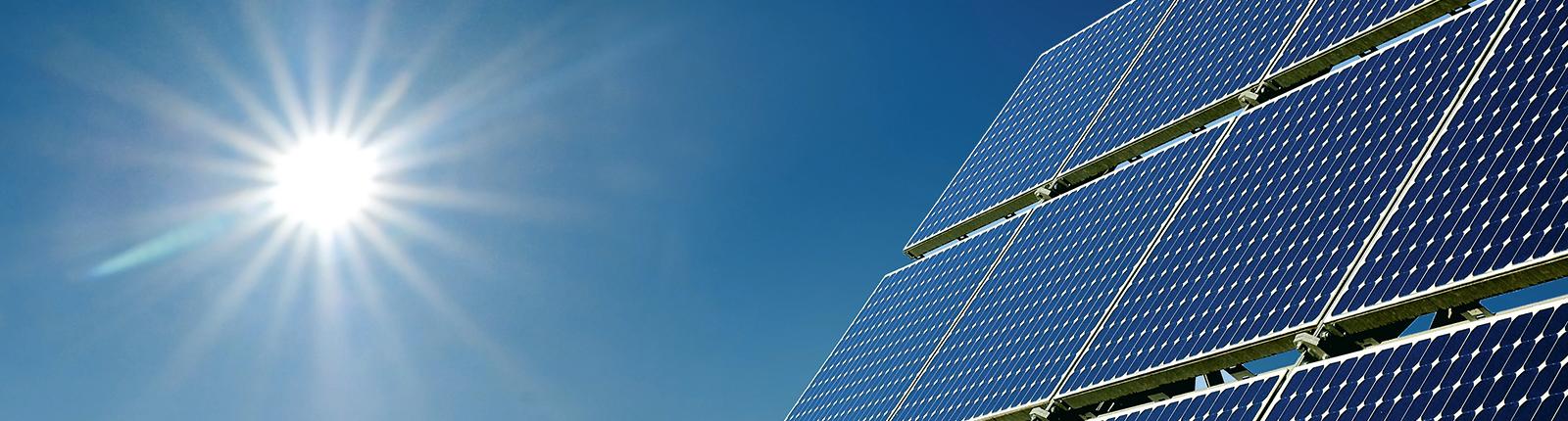 PV-Modul mit Himmel  und Sonne im Hintergrund